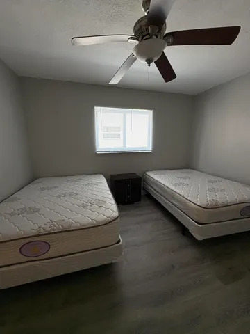 a living room with hard wood floors and a ceiling fan