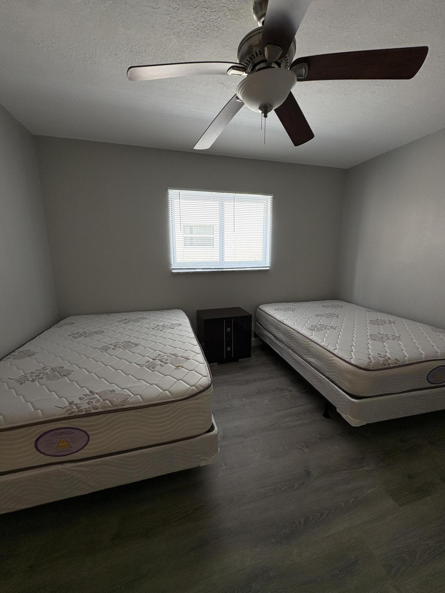 102 Stratford H, Unit A West Palm Beach, FL 33417 - Photo 4 of 19 a living room with hard wood floors and a ceiling fan