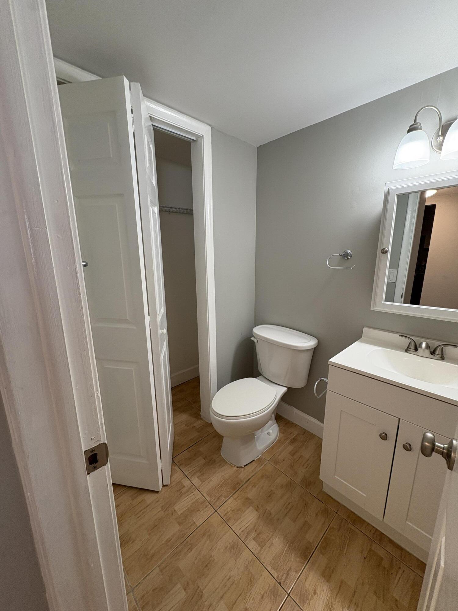 102 Stratford H, Unit A West Palm Beach, FL 33417 - Photo 6 of 19 a bathroom with a toilet sink and vanity