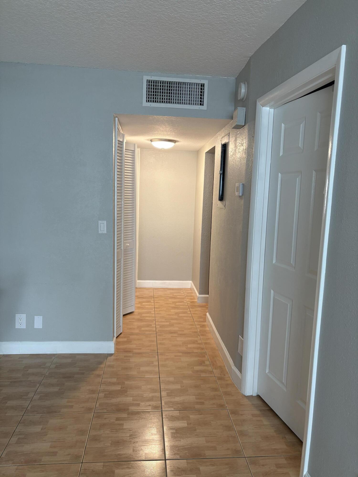 102 Stratford H, Unit A West Palm Beach, FL 33417 - Photo 10 of 19 a view of a hallway with wooden floor