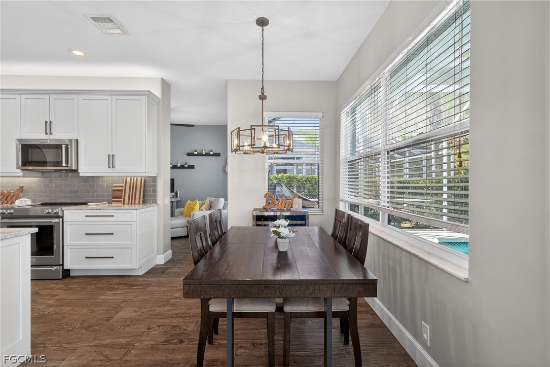 22866 Forest Ridge Drive Estero, FL 33928 - Photo 13 of 38 a kitchen that has a table chairs in it and wooden floors