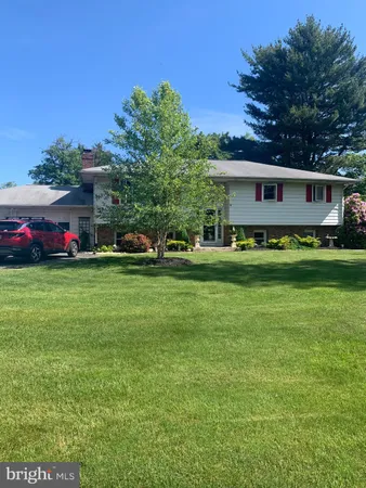 a front view of a house with a garden and trees