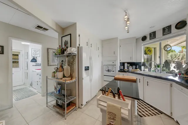 a room with stainless steel appliances kitchen island granite countertop furniture and a view of kitchen