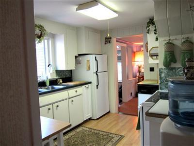79 Earle Road West Harwich, MA 02671 - Photo 13 of 30 a kitchen with stainless steel appliances granite countertop a refrigerator a sink dishwasher and white cabinets next to a window