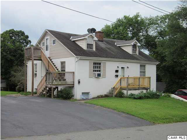 a front view of a house with a garden and parking