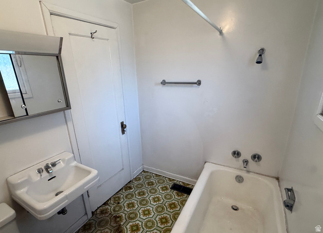 151 South Roosevelt Helper, UT 84526 - Photo 18 of 20 Bathroom featuring a wall-mounted sink, medicine cabinet with mirrored door, and patterned floor tile