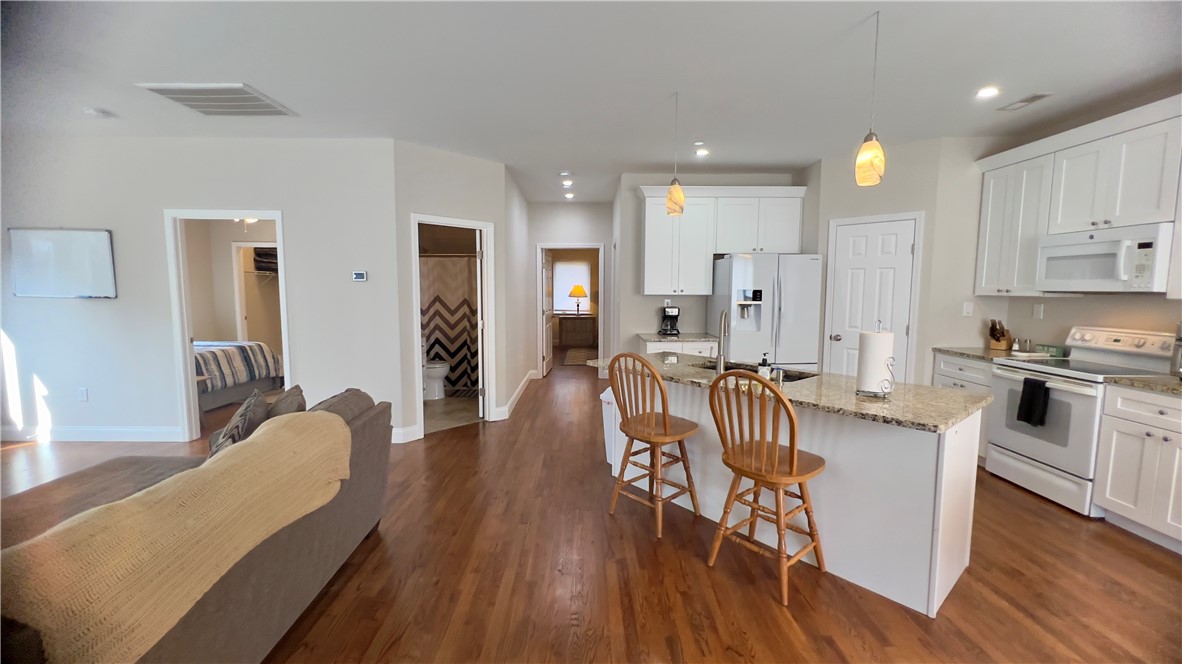 160 Hudgins Lake Road Townville, SC 29689 - Photo 11 of 41 Granite counters and hardwood floors grace this efficient kitchen with bright white cabinetry.