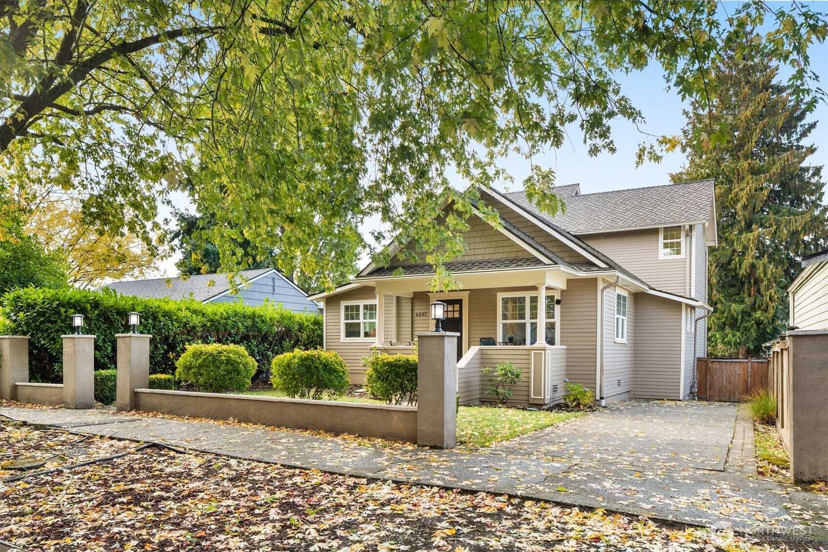 a front view of a house with a yard and potted plants