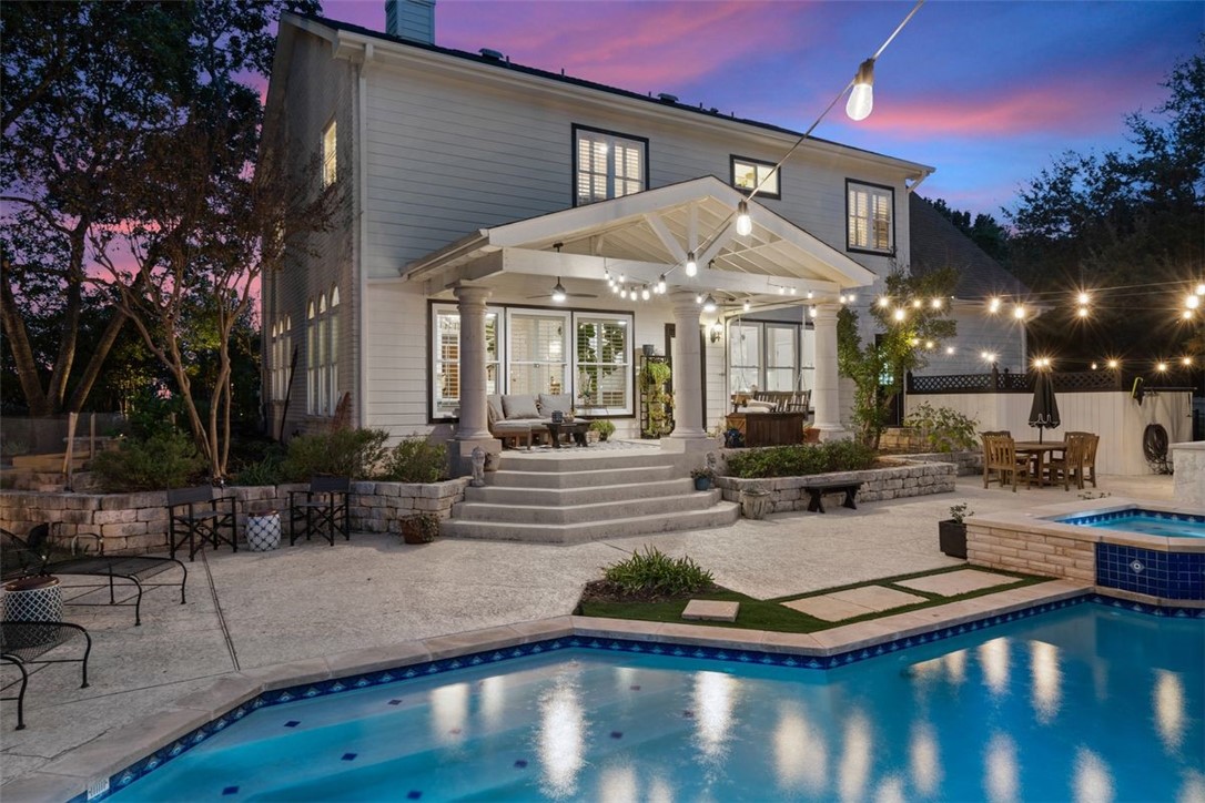 a view of a white building with swimming pool and sitting area