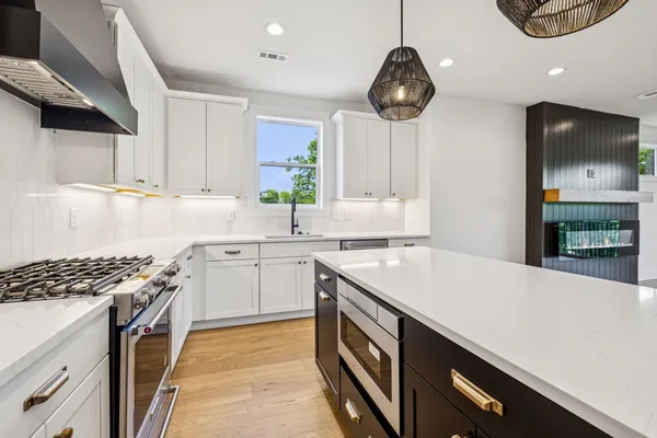 a kitchen with stainless steel appliances a stove a sink and a refrigerator