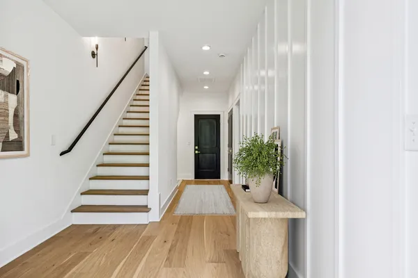a view of a hallway with wooden floor and entryway
