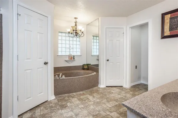 a bathroom with a tub a sink and a window