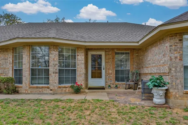 a front view of a house with a yard and trees