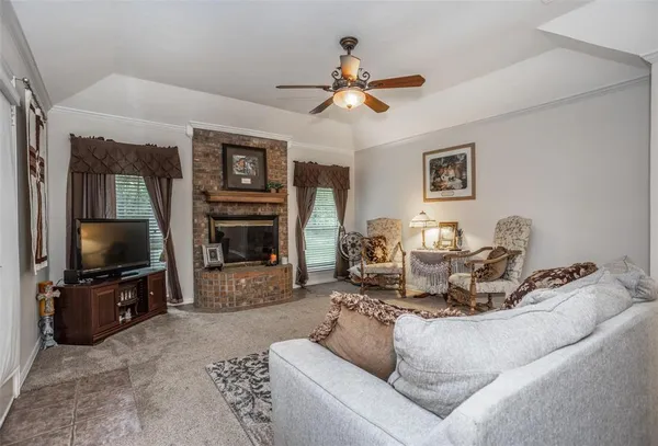 a living room with furniture a flat screen tv and a fireplace