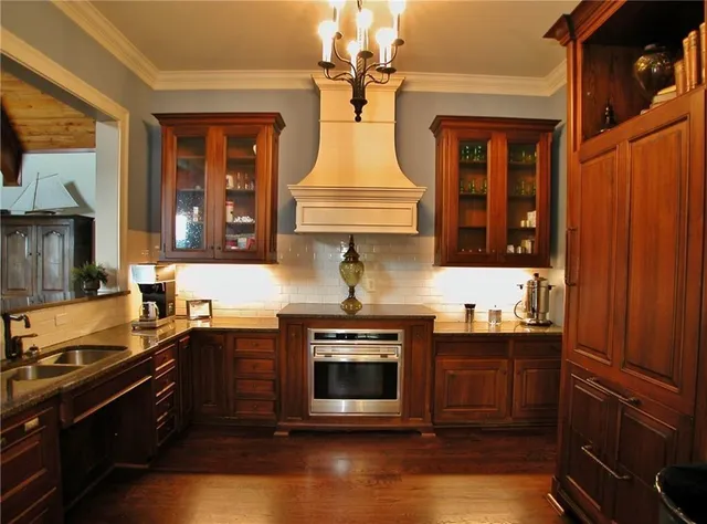 a kitchen with stainless steel appliances granite countertop a sink stove and cabinets