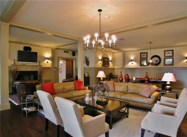 a living room with furniture kitchen view and a chandelier