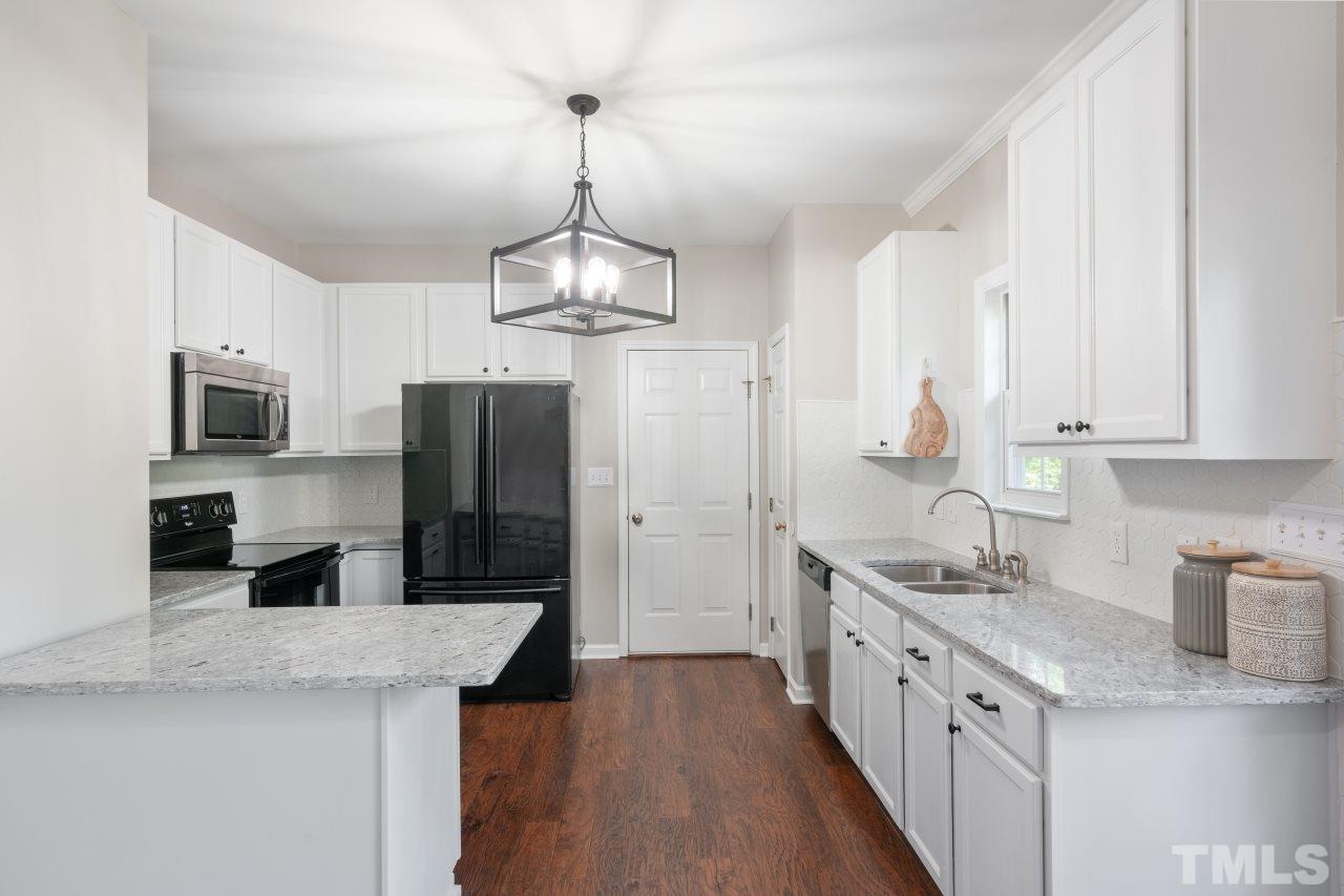 2133 Haig Point Way Raleigh, NC 27604 - Photo 7 of 28 a kitchen with stainless steel appliances a sink stove and refrigerator