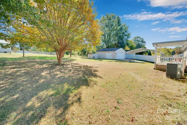 a white house with a small yard and trees