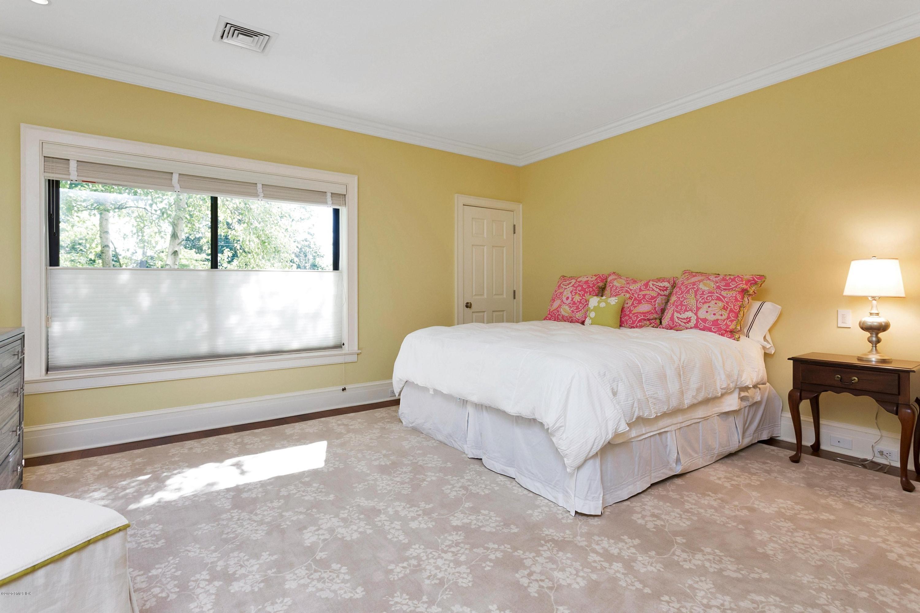 680 Steamboat Road, Unit 5 Greenwich, CT 06830 - Photo 13 of 21 a spacious bedroom with a bed lamp and a large window