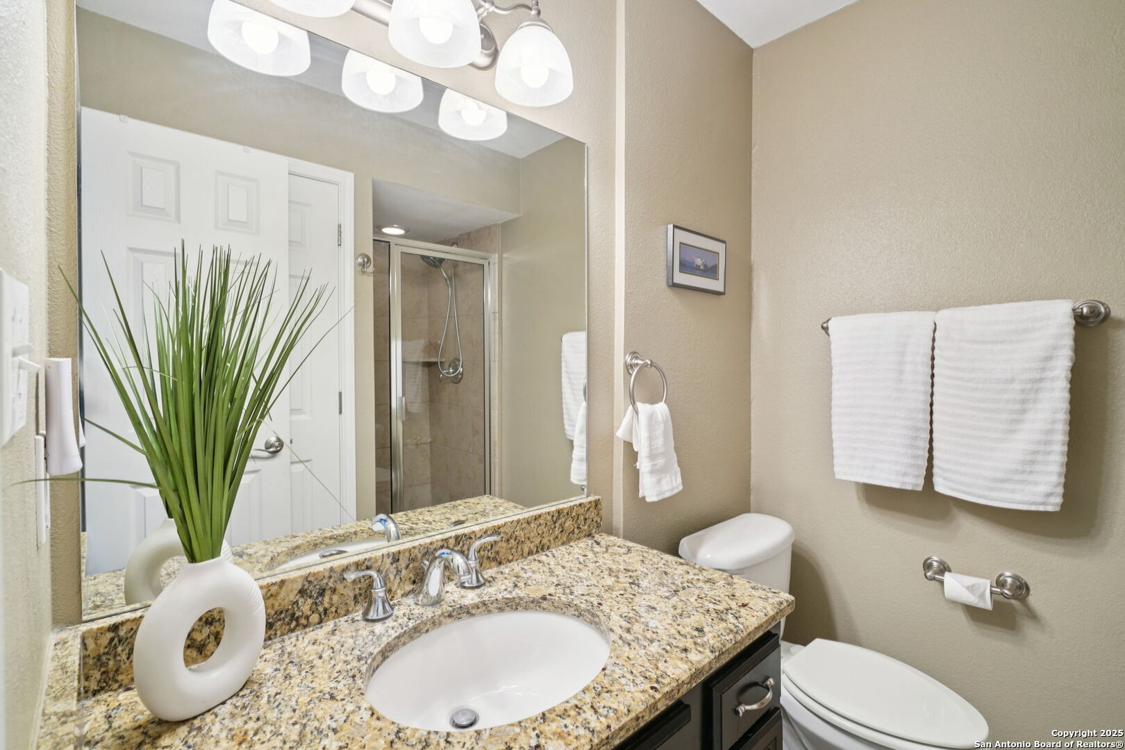 100 Lorenz Road, Unit 1204 San Antonio, TX 78209 - Photo 13 of 27 a bathroom with a granite countertop sink a mirror and a toilet