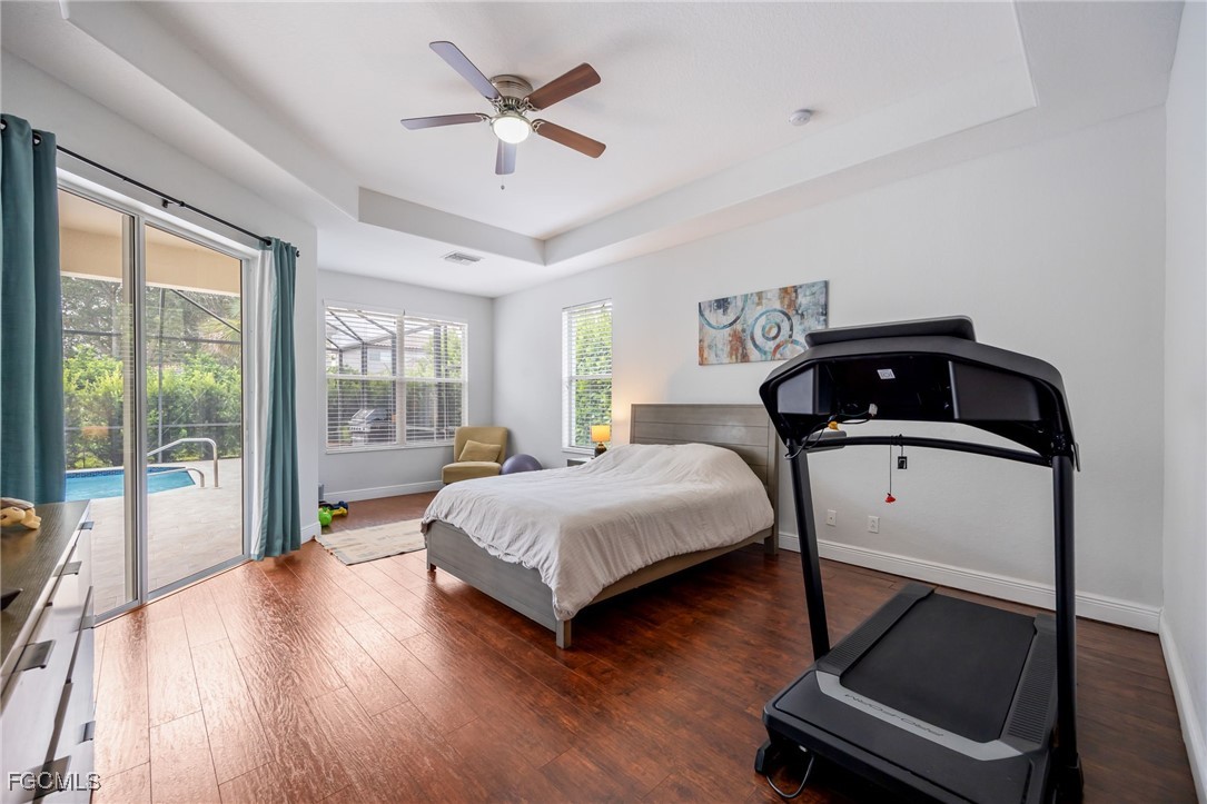 12406 Rock Ridge Lane Fort Myers, FL 33913 - Photo 13 of 35 a bedroom with a bed a chandelier and large window