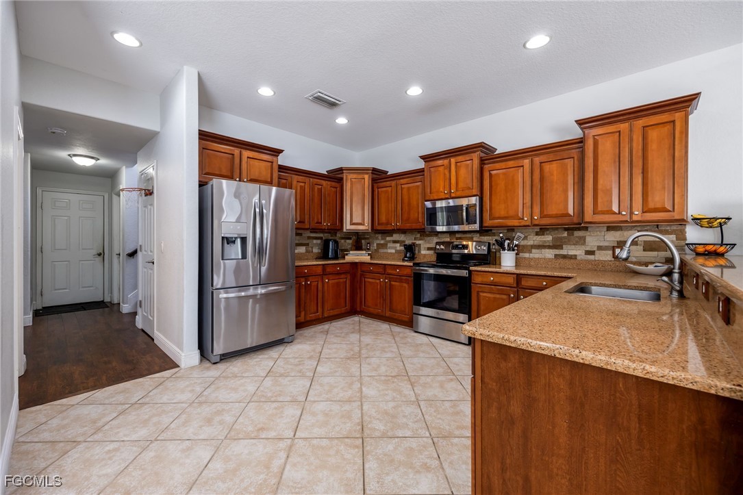 12406 Rock Ridge Lane Fort Myers, FL 33913 - Photo 8 of 35 a kitchen with stainless steel appliances granite countertop a refrigerator a stove top oven a sink and dishwasher