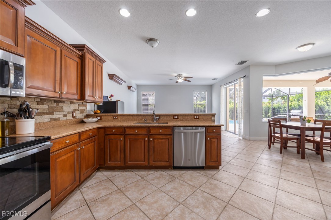 12406 Rock Ridge Lane Fort Myers, FL 33913 - Photo 10 of 35 a kitchen with stainless steel appliances granite countertop a stove a sink and a microwave