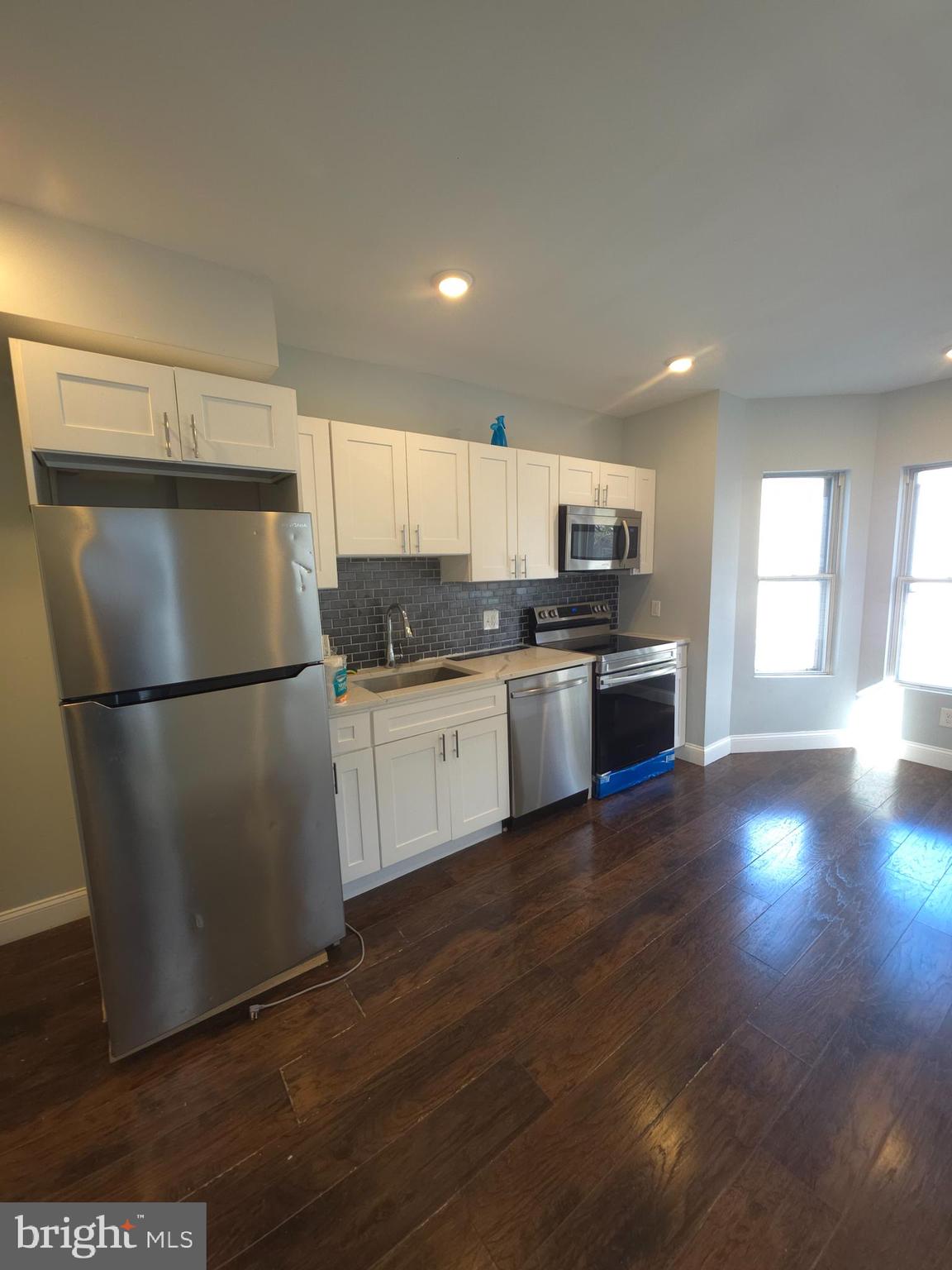 1135 West Somerset Street, Unit 2 Philadelphia, PA 19133 - Photo 4 of 15 a kitchen with granite countertop a refrigerator and a stove top oven
