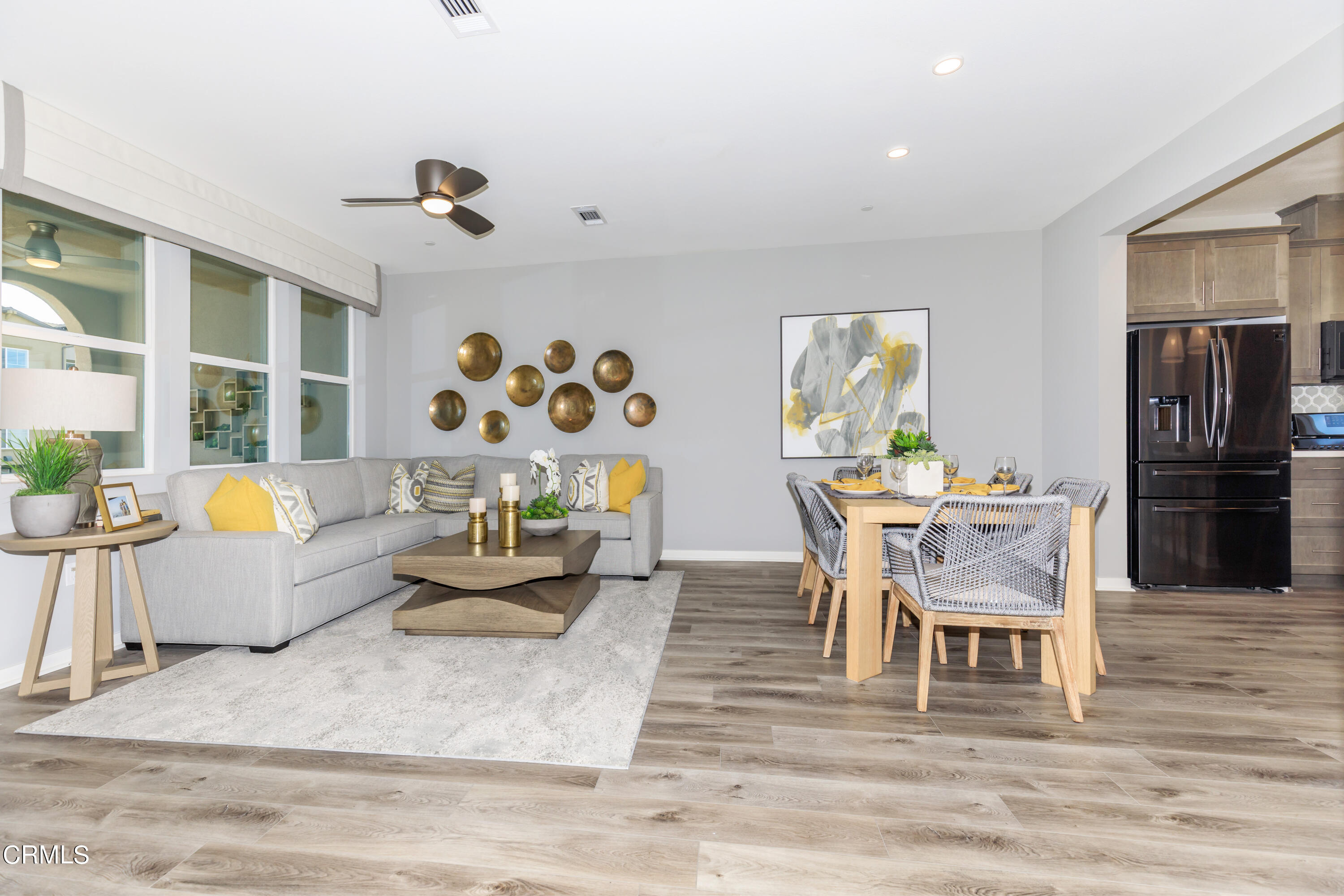 703 Winchester Drive Oxnard, CA 93036 - Photo 2 of 30 a dining room with wooden floor a chandelier a glass table and chairs