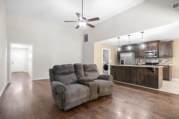 a living room with furniture and kitchen view