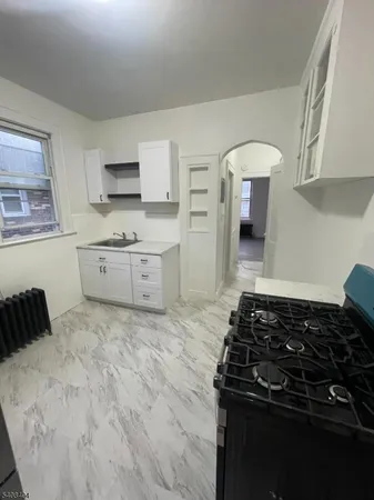 a kitchen with a stove and white cabinets