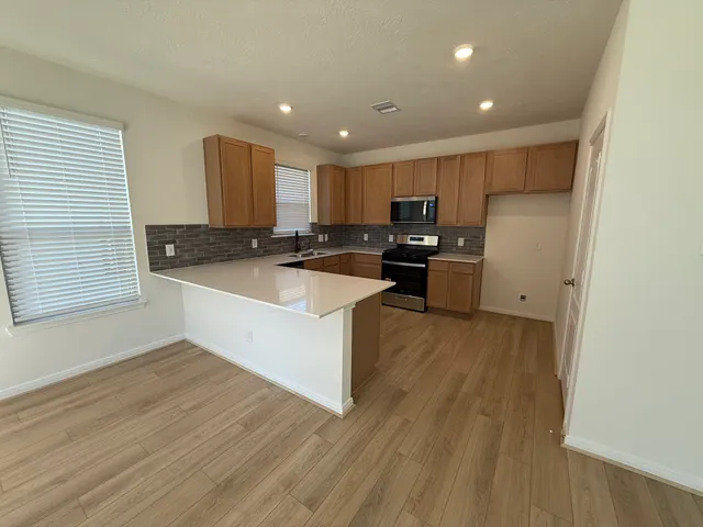 a kitchen with a refrigerator a stove top oven a sink and a counter top space