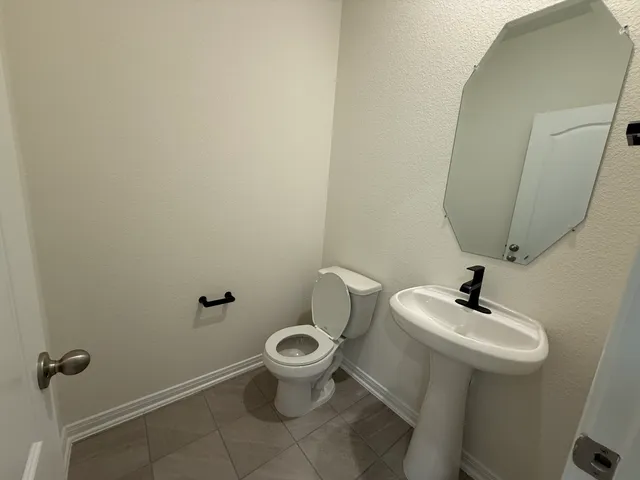 a bathroom with a sink mirror and toilet