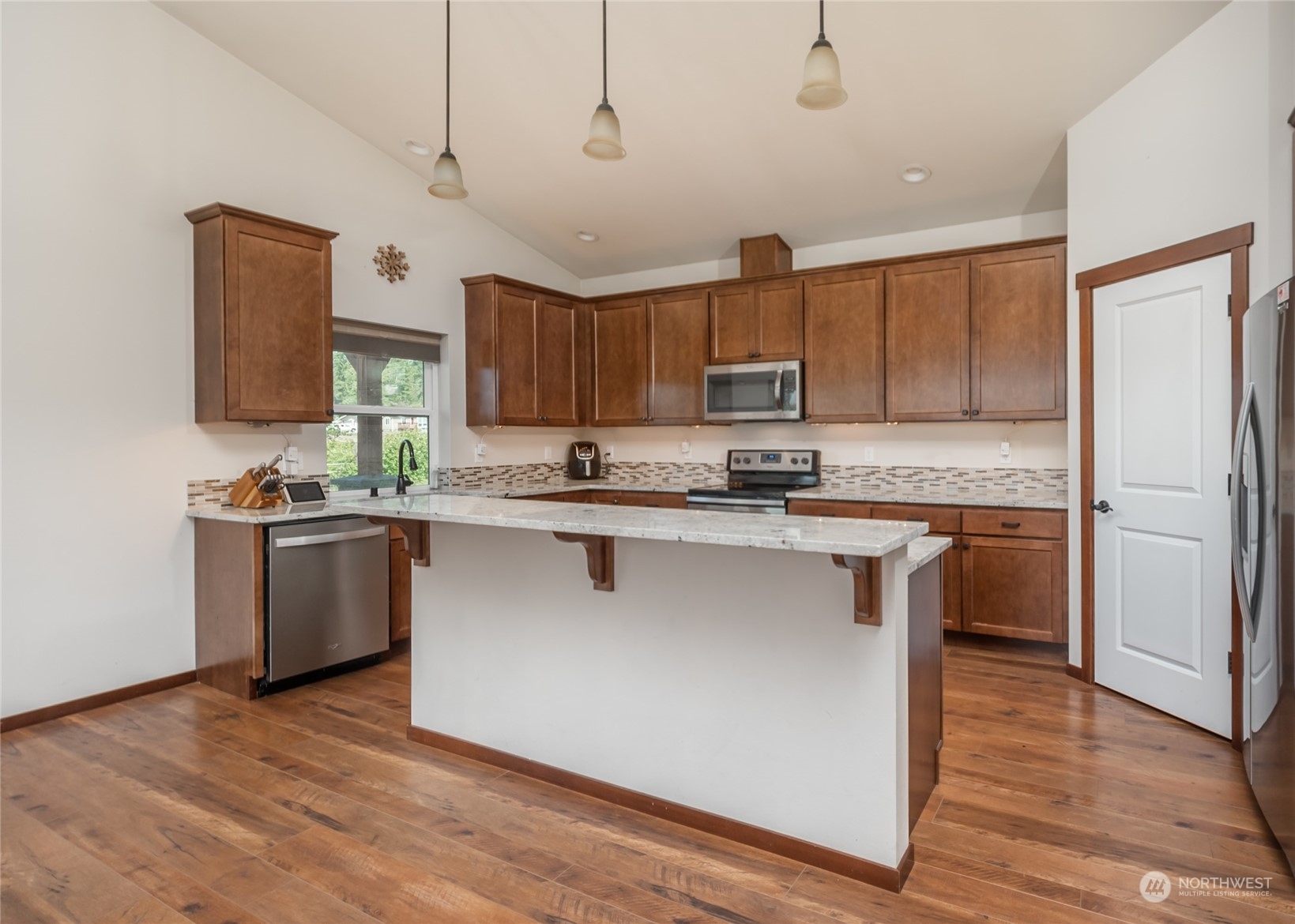 11 West Green Valley Road Oak Harbor, WA 98277 - Photo 5 of 36 a kitchen with stainless steel appliances granite countertop a refrigerator a stove top oven a sink and dishwasher with wooden floor