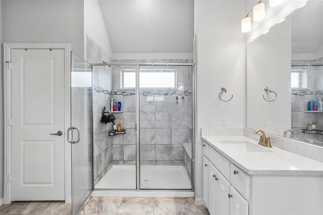 a bathroom with a shower sink and mirror