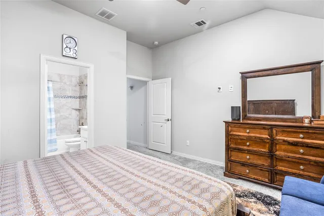 a bedroom with a bed and a mirror on dresser