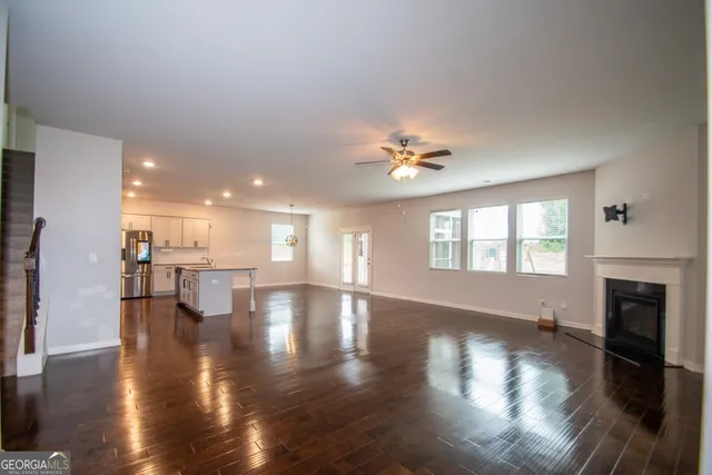 a view of empty room with wooden floor and fireplace
