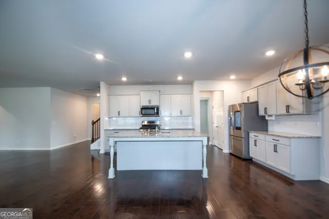 a kitchen with stainless steel appliances kitchen island hardwood floor sink and stove