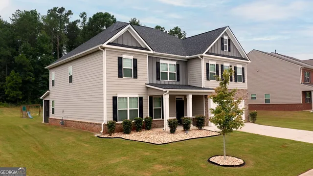 a front view of house with yard and trees in the background