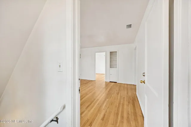 a view of a room with wooden floor and white doors