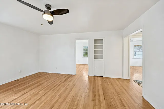 a view of empty room with wooden floor