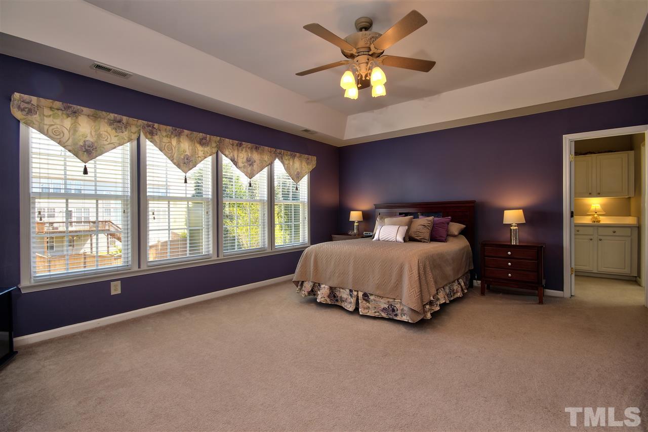 7616 Derek Drive Raleigh, NC 27613 - Photo 12 of 25 a bed sitting in a spacious bedroom next to a window