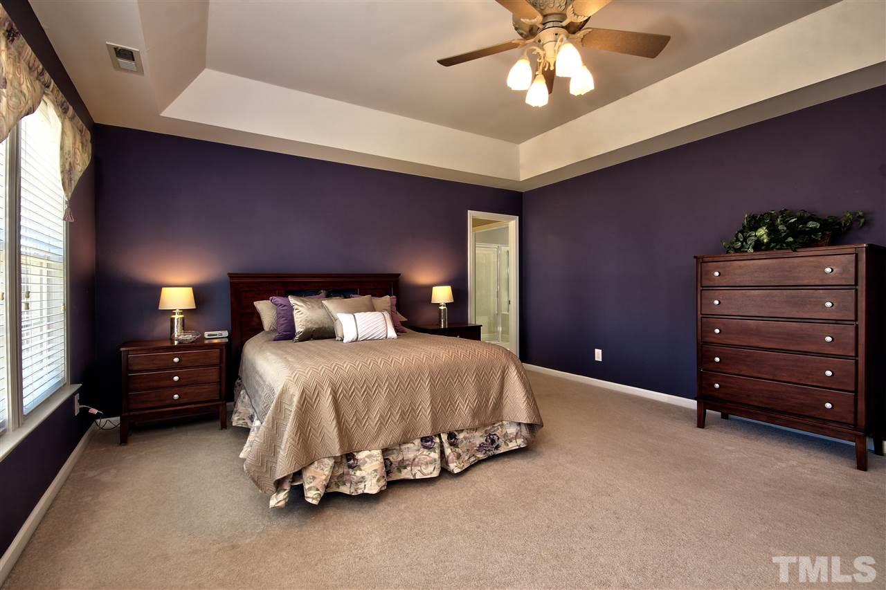 7616 Derek Drive Raleigh, NC 27613 - Photo 13 of 25 a bedroom with a bed and a ceiling fan
