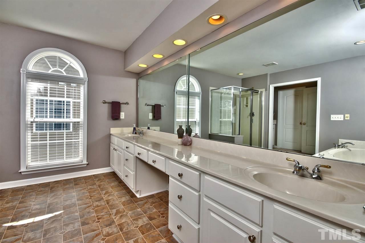 7616 Derek Drive Raleigh, NC 27613 - Photo 15 of 25 a spacious bathroom with a granite countertop sink mirror and a toilet
