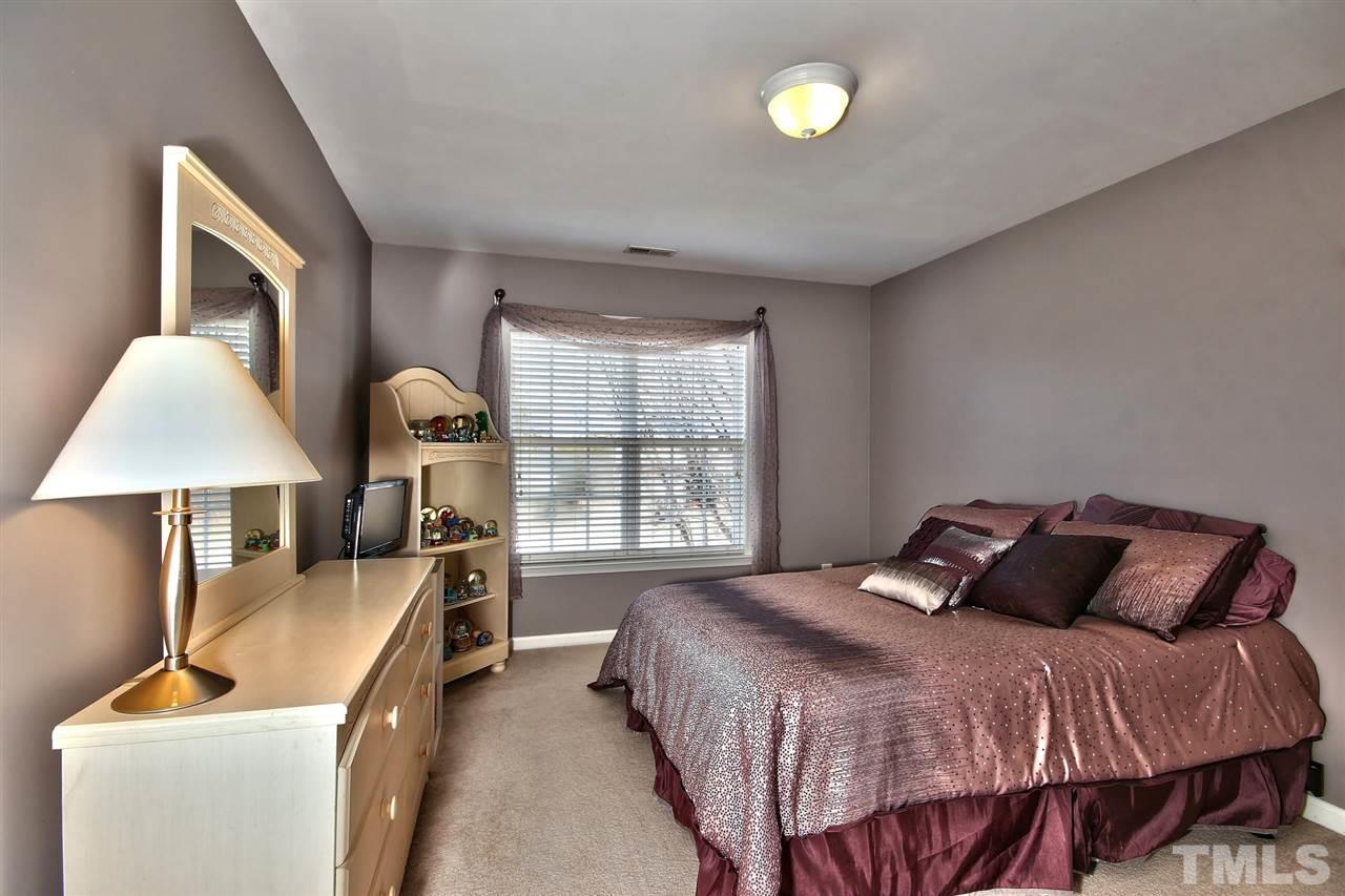 7616 Derek Drive Raleigh, NC 27613 - Photo 17 of 25 a bedroom with a bed and a lamp