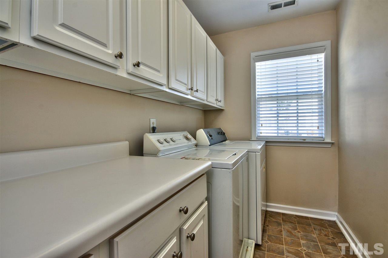 7616 Derek Drive Raleigh, NC 27613 - Photo 19 of 25 a utility room with a sink a cabinetry and a window