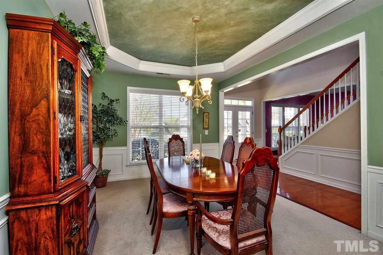 7616 Derek Drive Raleigh, NC 27613 - Photo 5 of 25 a dining room with furniture a chandelier and fireplace