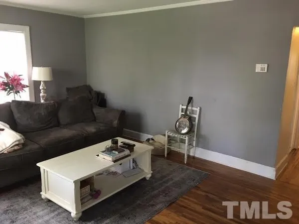a living room with a couch and a potted plant on a dresser