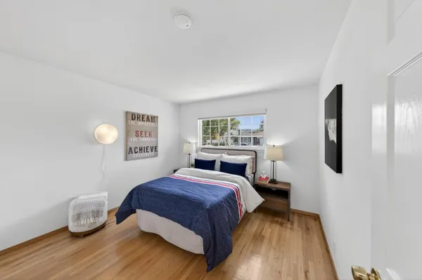 a bedroom with a bed and wooden floor