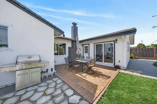 a view of a house with table and chairs in a patio
